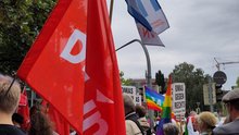 Das Bild zeigt eine Menschenmenge beim CSD und eine Linke-Fahne.