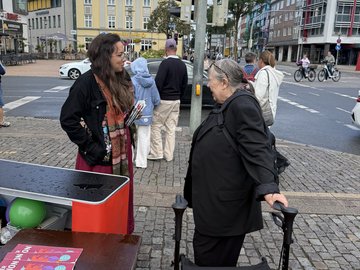 Tamara Mazzi ist am Infostand im Gespräch mit einer älteren Dame.